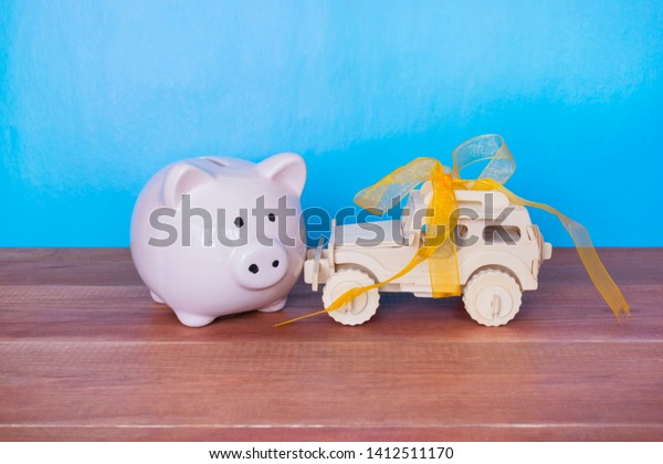 Toy car and\
piggy bank on the blue backgound.\
