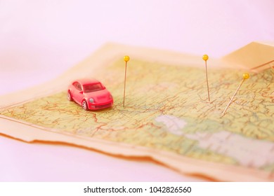 toy car and Pin marking location on geographical map. Adventure and travel background. Road trip concept. - Powered by Shutterstock