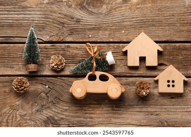 Toy car with small Christmas trees, pine cones and houses on wooden background - Powered by Shutterstock