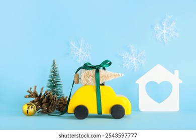 Toy car with small Christmas trees, pine cones and house on blue background - Powered by Shutterstock