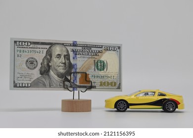 A Toy Car Stands Next To A Banknote On A Stand. Accurate Financial Calculation When Buying A Car