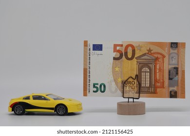 A Toy Car Stands Next To A Banknote On A Stand. Accurate Financial Calculation When Buying A Car