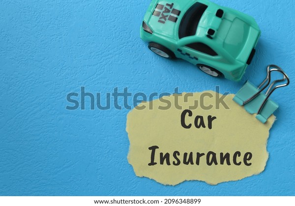 Toy car and\
torn paper with text CAR\
INSURANCE