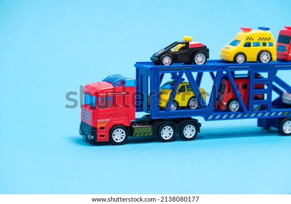 Toy car transporter with cars on a blue\
background, for a toy\
store.