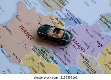 Toy car travels on Europe map, sitting view, vacation and destination concept, miniature green sport car going to France from Germany, worldwide tour, Europe map idea, holiday in France - Powered by Shutterstock