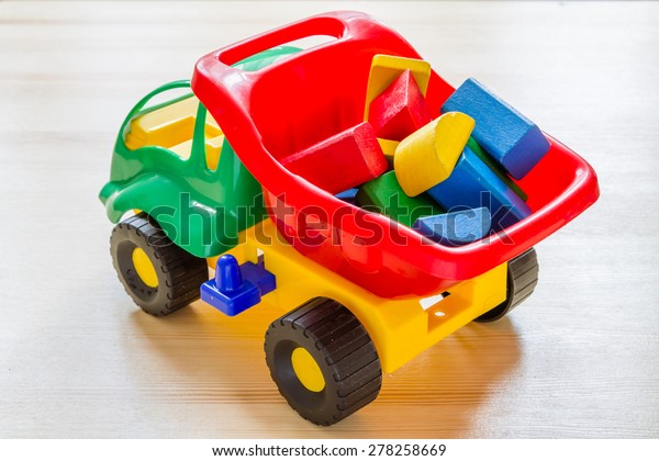 Toy car truck with bricks\
in vessel