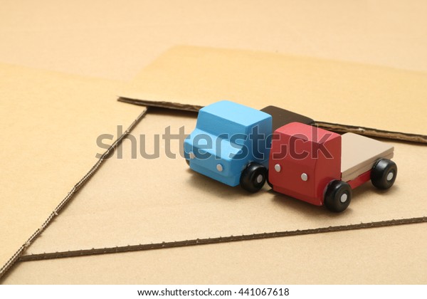 Toy car trucks\
on cardboard. logistics\
image.
