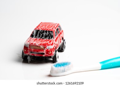 Toy Car In White Foam Which Caused A Toothbrush, Car Wash On A White Background