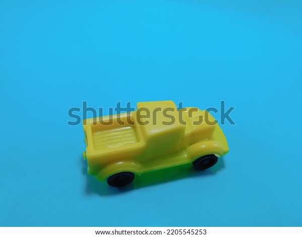 toy car,\
yellow color vehicle on blue\
background.