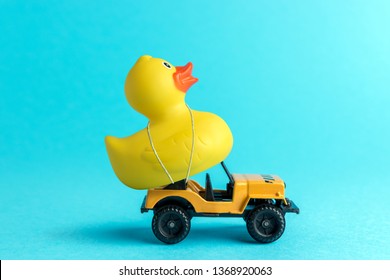 Toy Car And Yellow Rubber Duck On Blue Background. Summer Minimal Concept.