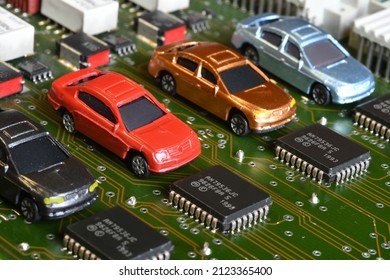 Toy Cars On Electronic Board And Microchip. Conceptual Image For Semiconductor Shortage Disrupting Production Of The Automotive Industry.