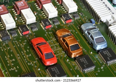 Toy Cars On Electronic Board And Microchip. Conceptual Image For Semiconductor Shortage Disrupting Production Of The Automotive Industry.