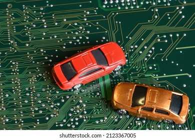 Toy Cars On An Electronic Board With Integrated Circuits. Conceptual Image For Semiconductor Shortage Disrupting Production Of The Automotive Industry.