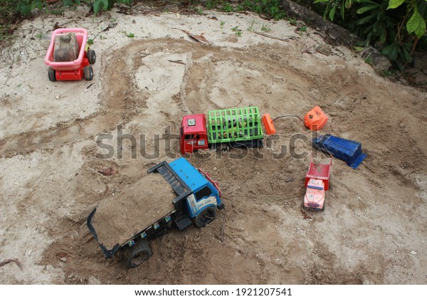 Toy cars scattered on the\
sand