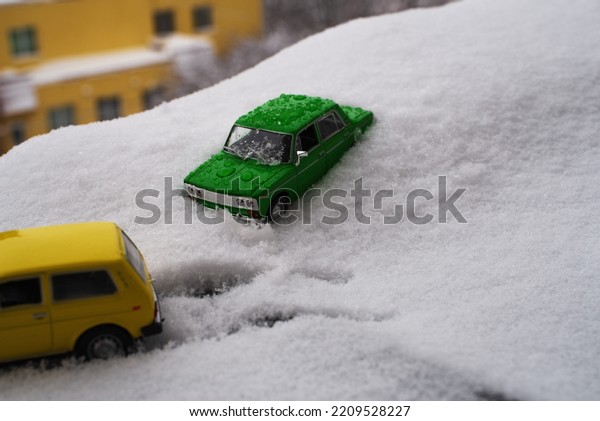toy cars stuck in\
deep snow in the cold