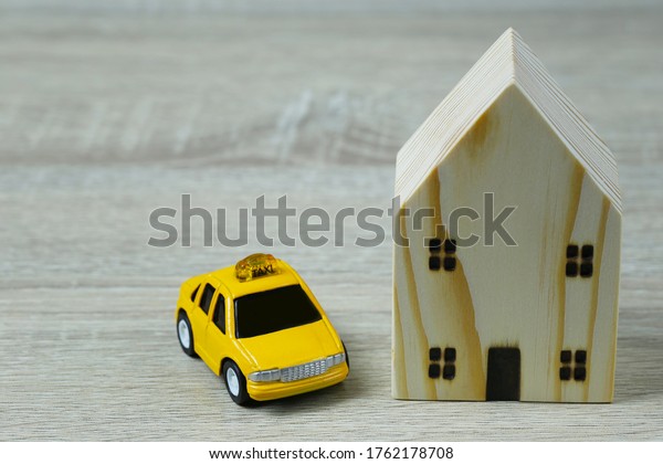 Toy cars and wooden houses in concept\
of buying housing and insurance or Travel\
concept.