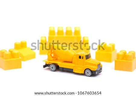 Toy cement mixers car and yellow toys brick on white background copy space