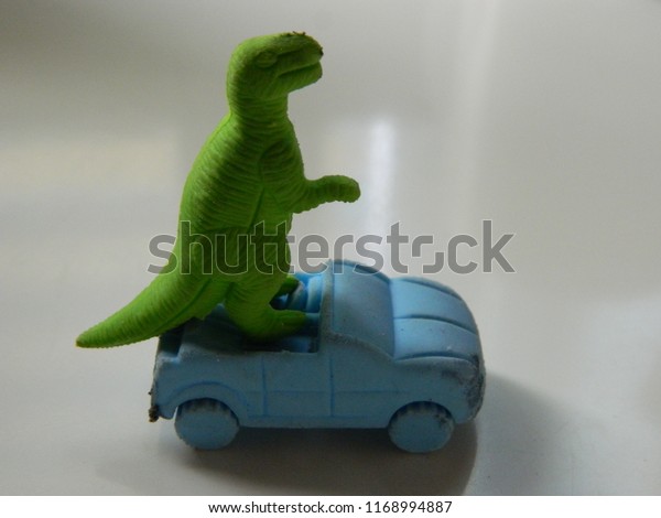 Toy dinosaur driving a\
car