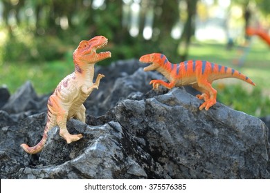 Toy dinosaur standing on a rock, doll tyrannosaurus - Shutterstock ID 375576385