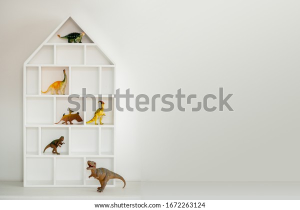 Toy dinosaur storage house shelf . Boys\
bedroom. Boyhood. Childhood with copy\
space.