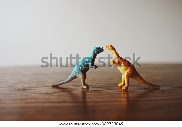 Toy dinosaurs on a\
table.