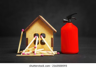 Toy fire extinguisher and matchsticks placed by a small wooden house model on black background. Fire safety and protection concept. - Shutterstock ID 2163500593