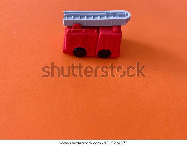 A toy\
fire track vehicle with an orange\
background