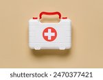 Toy first aid kit on beige background. Top view