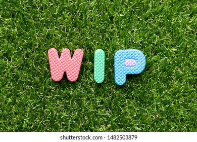 Toy foam letter in word WIP (Abbreviation of work in progress)  on green grass background