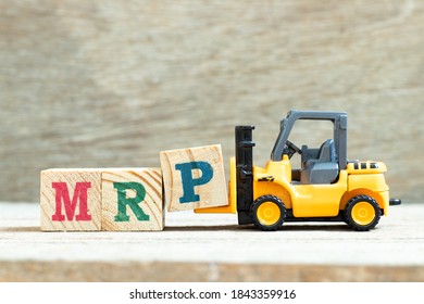 Toy forklift hold letter block P to complete word  MRP (Abbreviation of Material requirements planning) on wood background