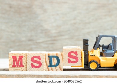 Toy Forklift Hold Letter Block S To Complete Word MSDS (Abbreviation Of Material Safety Data Sheet) On Wood Background