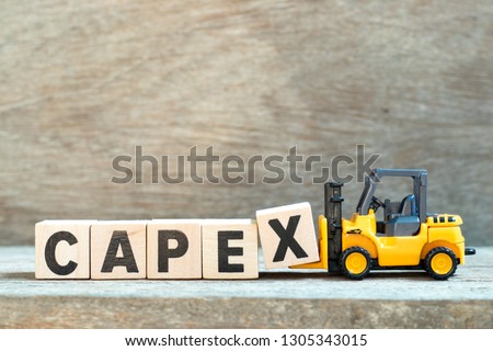 Toy forklift hold letter block x to complete word capex (abbreviation of capital expenditures) on wood background