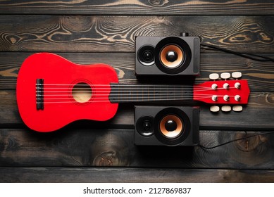 Toy Guitar And Musical Speaker On The Wooden Flat Lay Table Background