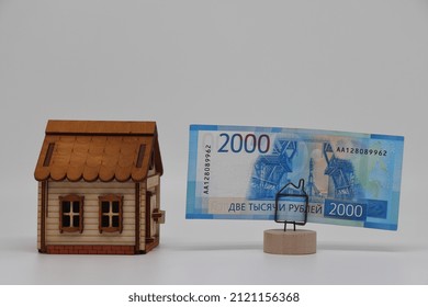 The Toy House Stands Next To The Banknote On The Stand. Accurate Financial Calculation When Buying A Property