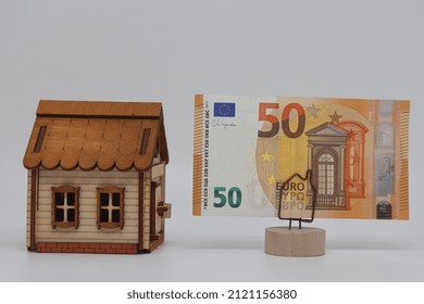 The Toy House Stands Next To The Banknote On The Stand. Accurate Financial Calculation When Buying A Property