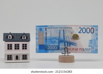 The Toy House Stands Next To The Banknote On The Stand. Accurate Financial Calculation When Buying A Property