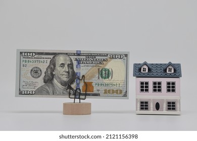 The Toy House Stands Next To The Banknote On The Stand. Accurate Financial Calculation When Buying A Property