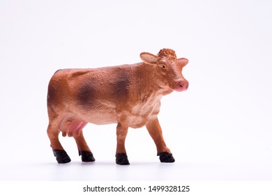 Toy Miniature Cow On A Isolated White Background