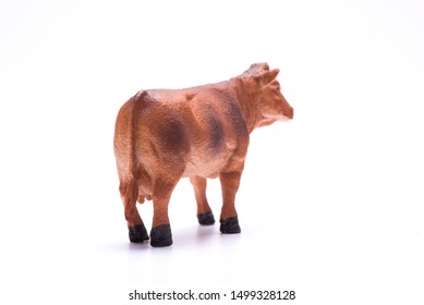 Toy Miniature Cow On A Isolated White Background