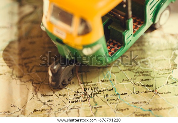 Toy model of auto\
rickshaw vehicle driving on India map with many cities and the\
capital in Delhi