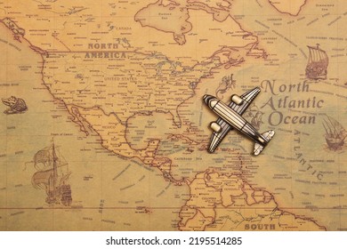 Toy Model Plane, Classic Vintage Small Passenger Airplane On The Vintage Style Map Background. Arriving USA East Coast From Atlantic Ocean