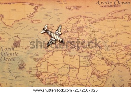 Toy model plane, classic vintage small passenger airplane on the vintage style map background flying above the Europe