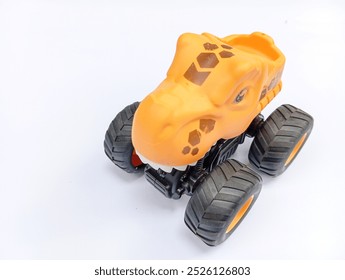 toy monster truck, The image shows a yellow toy monster truck with a dinosaur head. The truck has large, on white background 