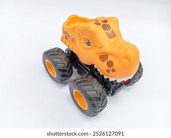 toy monster truck, The image shows a yellow toy monster truck with a dinosaur head. The truck has large, on white background 
