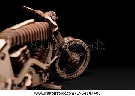 Toy motorcycle made of plywood on a black background
