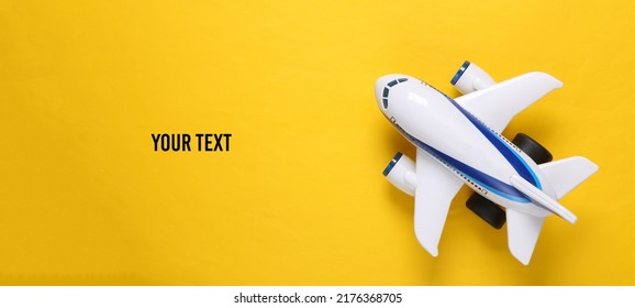 Toy Passenger Plane On Yellow Background. Travel Concept. Copy Space. Top View