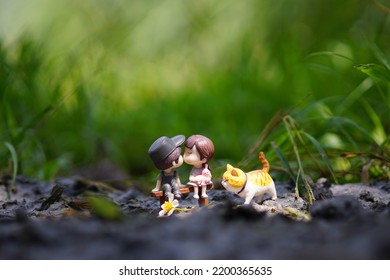 Toy Photo Of Two People Kissing Accompanied By Their Favorite Animal In A Jakarta City Park