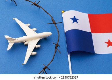 Toy plane, flag and barbed wire on blue background, Panama closed air border concept