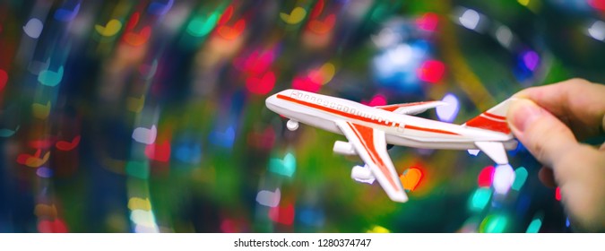 Toy plane hand. Flight simulation. Abstract colorful background with heart-shaped bokeh. Blue, purple, green, red colors. - Shutterstock ID 1280374747