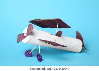 Toy Plane Made Of Toilet Paper Hub On Light Blue Background